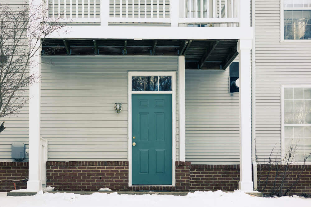 Входна врата на къща и сняг
